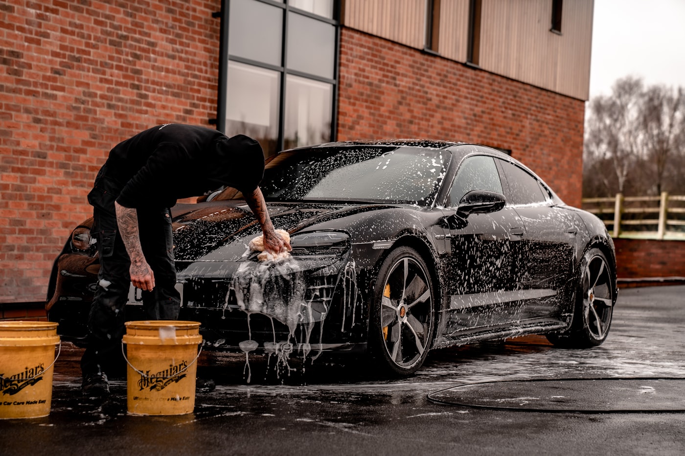 Detailing studio bay with a car mid-service and equipment set up