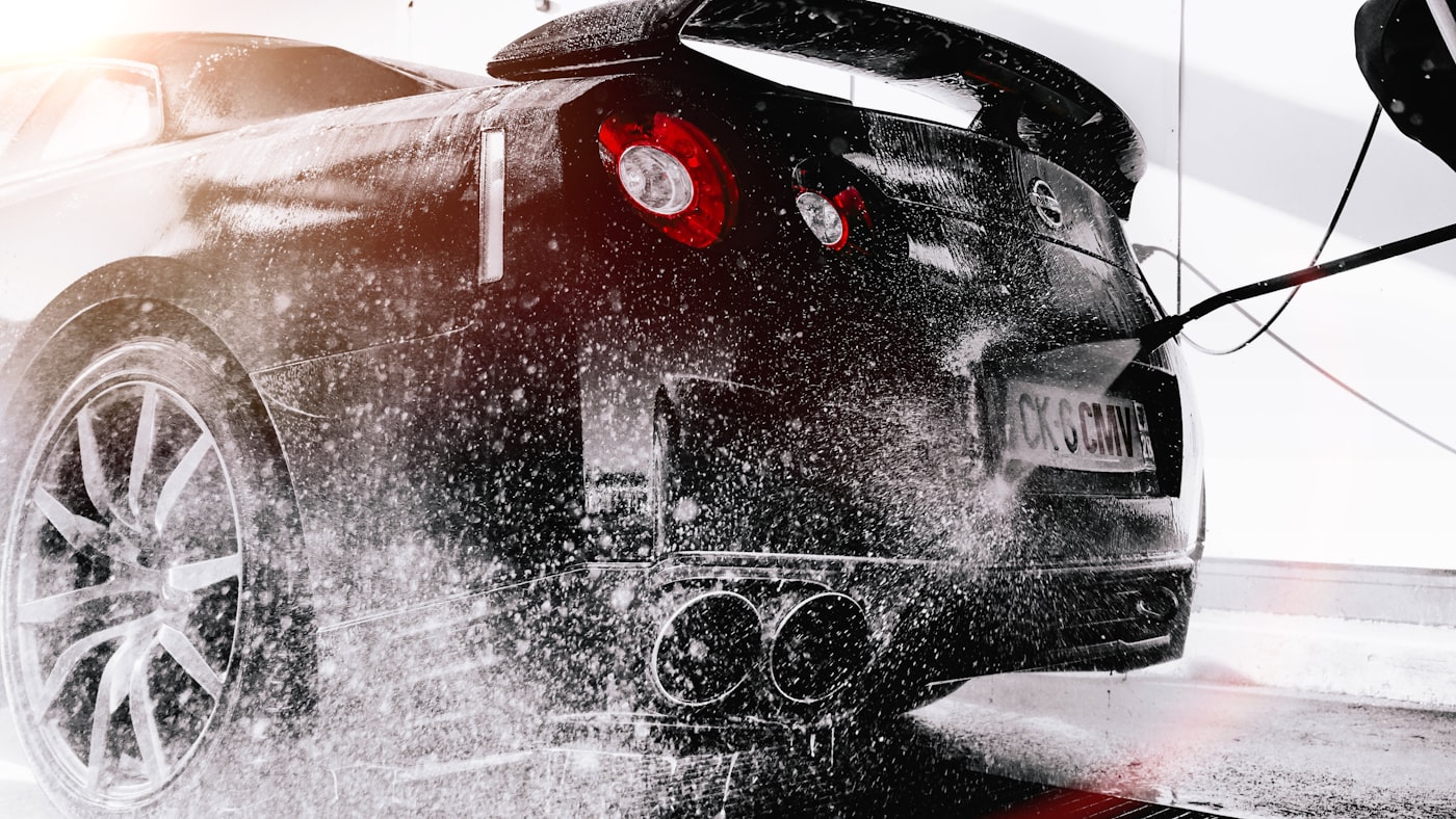 Detailer polishing a car exterior inside a professional detailing studio in Jaipur